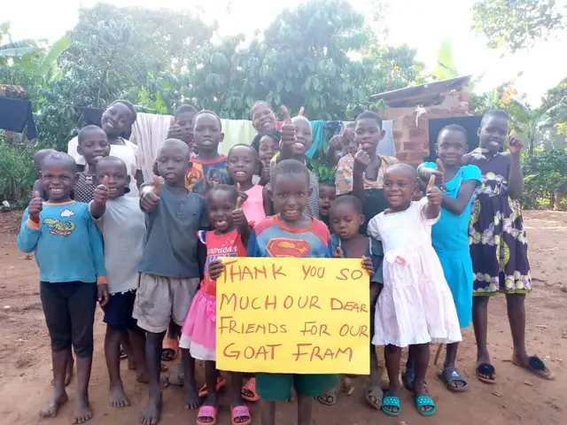 Smiling children giving a thumbs up behind a hand-lettered thank you sign