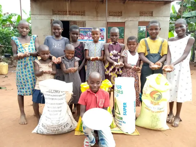 Children presenting handfuls of rice and beans harvested from the home garden