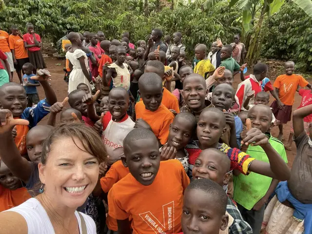 Robin Spillias with a crowd of children in colorful shirts at Portia's House